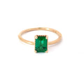 Gold ring with a green gemstone on a white background